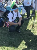 Zachary takes a knee while taking a request for a balloon at the festival.