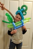 Damian B. poses with multiple balloons at a family event.